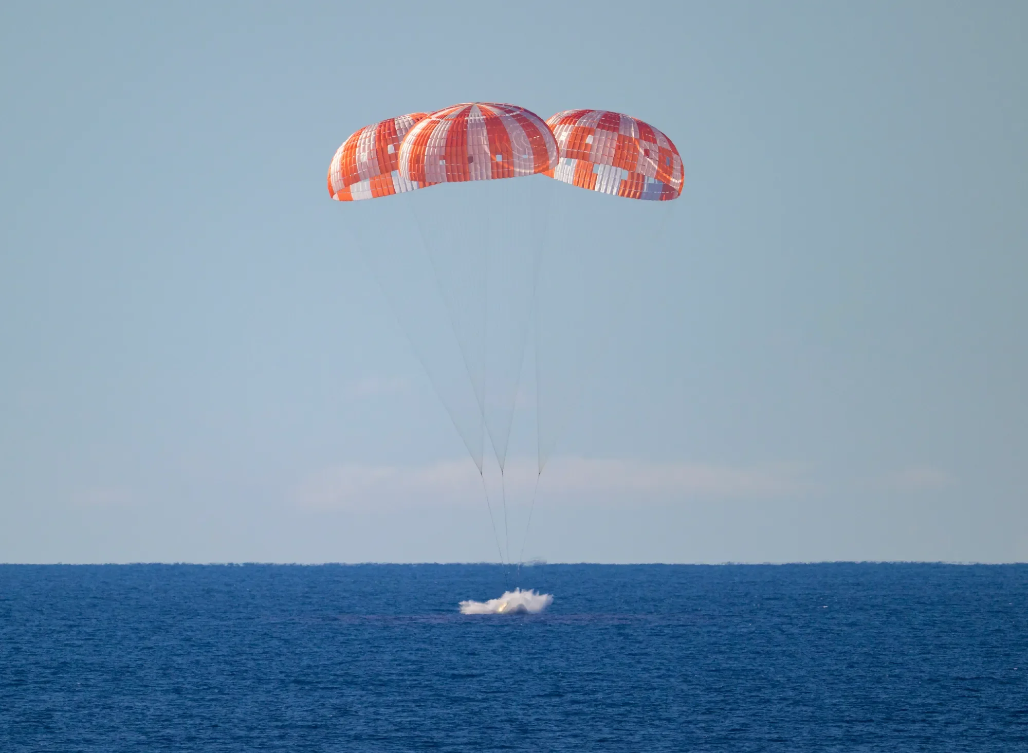 NASA’s Orion spacecraft with Artemis II crewmembers NASA astronauts Reid Wiseman, commander; Victor Glover, pilot; Christina Koch, mission specialist; and CSA (Canadian Space Agency) astronaut Jeremy Hansen, mission specialist aboard is seen as it lands in the Pacific Ocean off the coast of California, Friday, April 10, 2026 at 8:07 p.m. EDT. NASA’s Artemis II mission took Wiseman, Glover, Koch, and Hansen on a nearly 10-day journey around the Moon and back to Earth. Following a splashdown at , NASA, U.S. Navy, and U.S. Air Force teams are working to bring the crewmembers and Orion spacecraft aboard USS John P. Murtha. NASA/Bill Ingalls