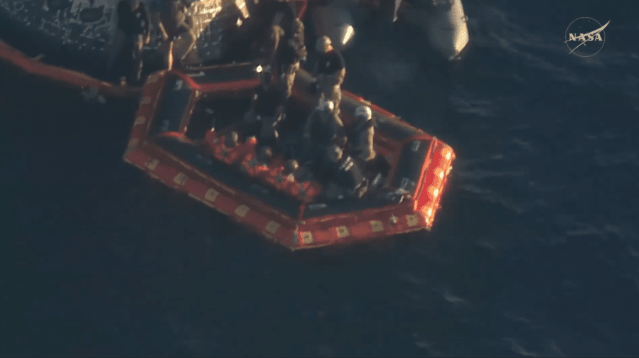 The Artemis II crew is seen on an inflatable raft, called the front porch, after exiting the spacecraft. The Artemis II mission successfully splashed down in the Pacific Ocean at 8:07 p.m. EDT on April 10, 2026. NASA