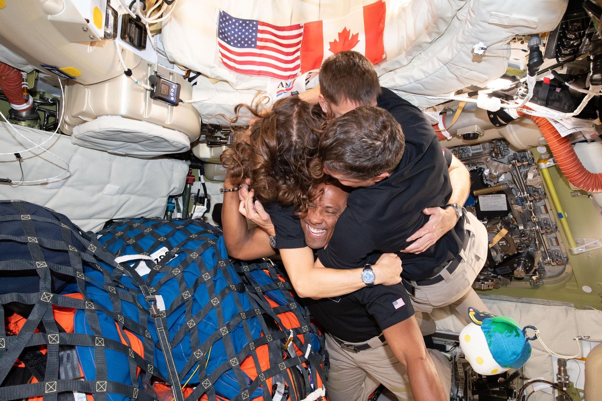 The Artemis II crew – (clockwise from left) Mission Specialist Christina Koch, Mission Specialist Jeremy Hansen, Commander Reid Wiseman, and Pilot Victor Glover – take time out for a group hug inside the Orion spacecraft on their way home. NASA