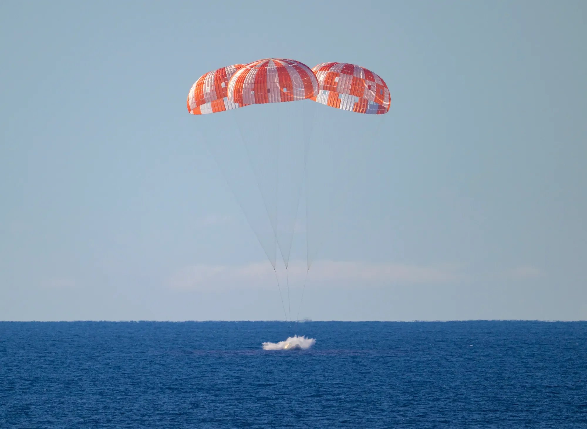 NASA’s Orion spacecraft with Artemis II crewmembers NASA astronauts Reid Wiseman, commander; Victor Glover, pilot; Christina Koch, mission specialist; and CSA (Canadian Space Agency) astronaut Jeremy Hansen, mission specialist aboard is seen as it lands in the Pacific Ocean off the coast of California, Friday, April 10, 2026 at 8:07 p.m. EDT. NASA’s Artemis II mission took Wiseman, Glover, Koch, and Hansen on a nearly 10-day journey around the Moon and back to Earth. Following a splashdown at , NASA, U.S. Navy, and U.S. Air Force teams are working to bring the crewmembers and Orion spacecraft aboard USS John P. Murtha. NASA/Bill Ingalls